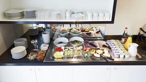 Montaje de bufé con distintos alimentos y utensilios.