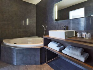 A modern bathroom with a freestanding bathtub, a built-in sink, and a vanity with towels. - Kyriad Troyes Centre (Troyes)
