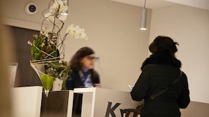 Una recepción con un logotipo, una planta en maceta y una lámpara colgante.
