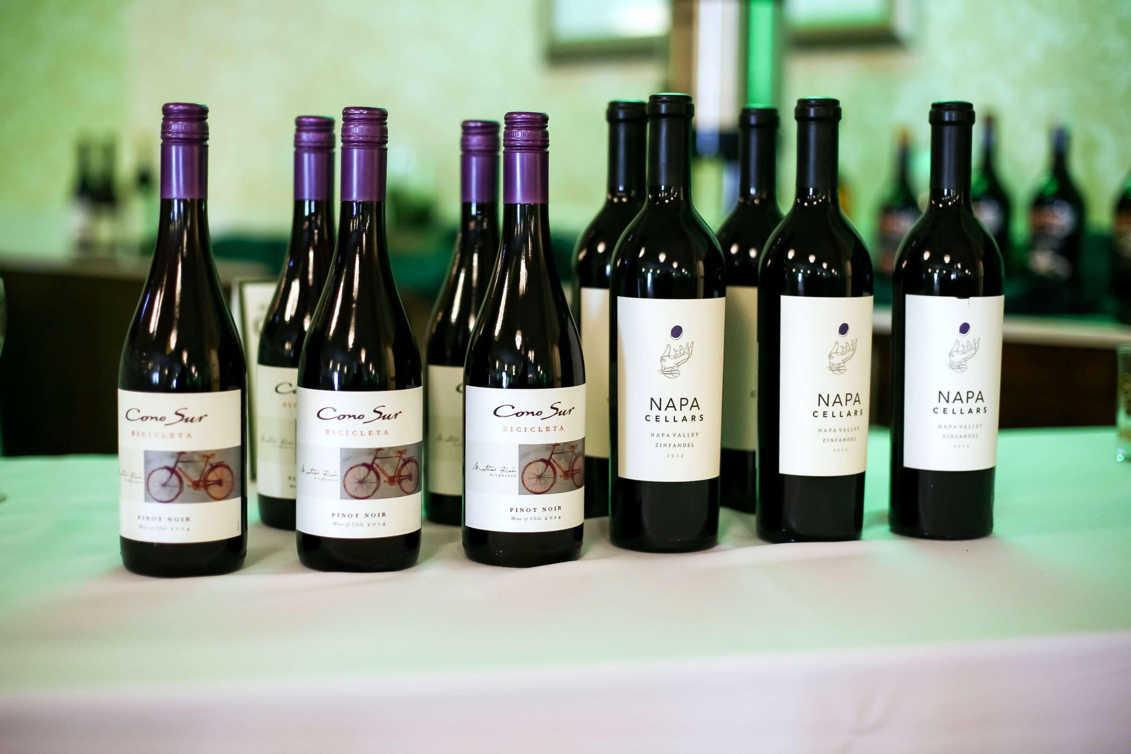 A row of wine bottles on a table.