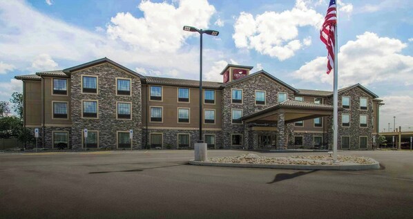 Ein mehrstöckiges Hotel mit einer Stein-Fassade, einer Fahnenstange mit der US-amerikanischen Flagge und einem überdachten Eingang.