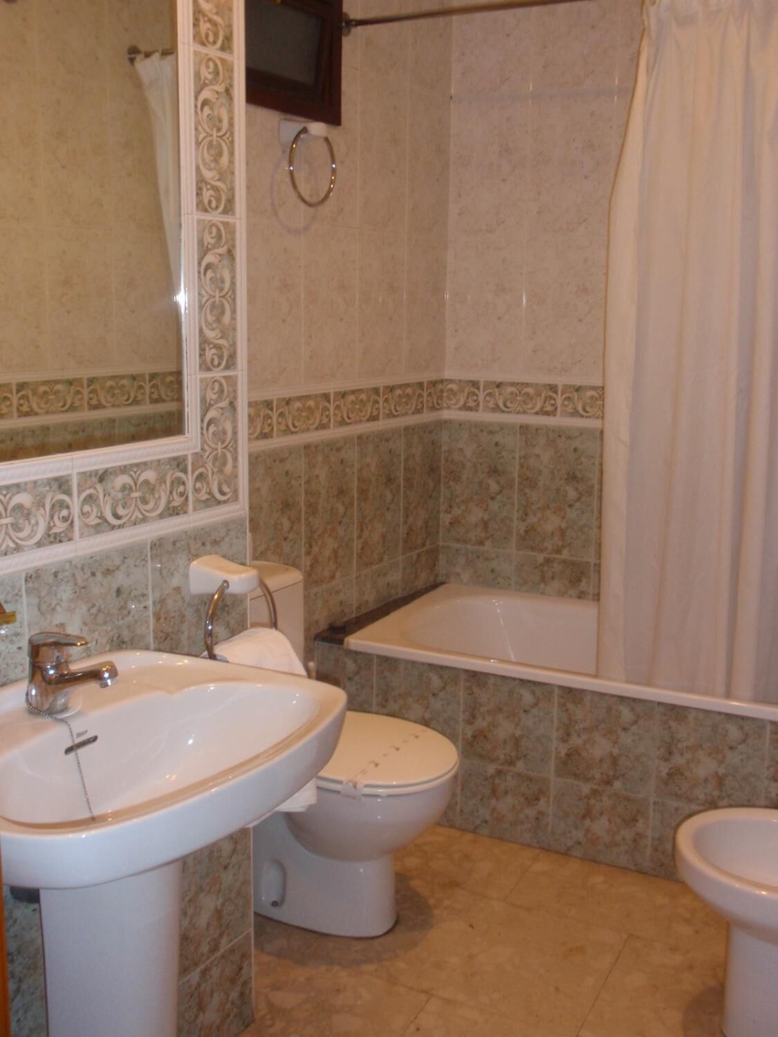 Une salle de bain avec un lavabo, des toilettes et une baignoire.