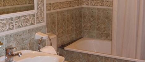 Une salle de bain avec un lavabo, des toilettes et une baignoire.