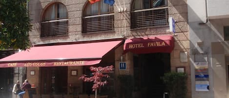 Rakennuksessa on punainen markiisi, jossa lukee ”HOTEL FAVILA”, ja kyltti, jossa on merkitty huoneiden numerot ”11” ja ”37”.
