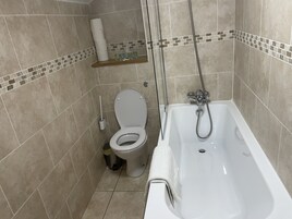 Un baño con inodoro, ducha y bañera.