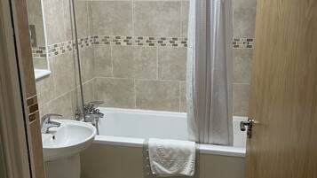 A bathroom with a bathtub, a sink, and a shower.