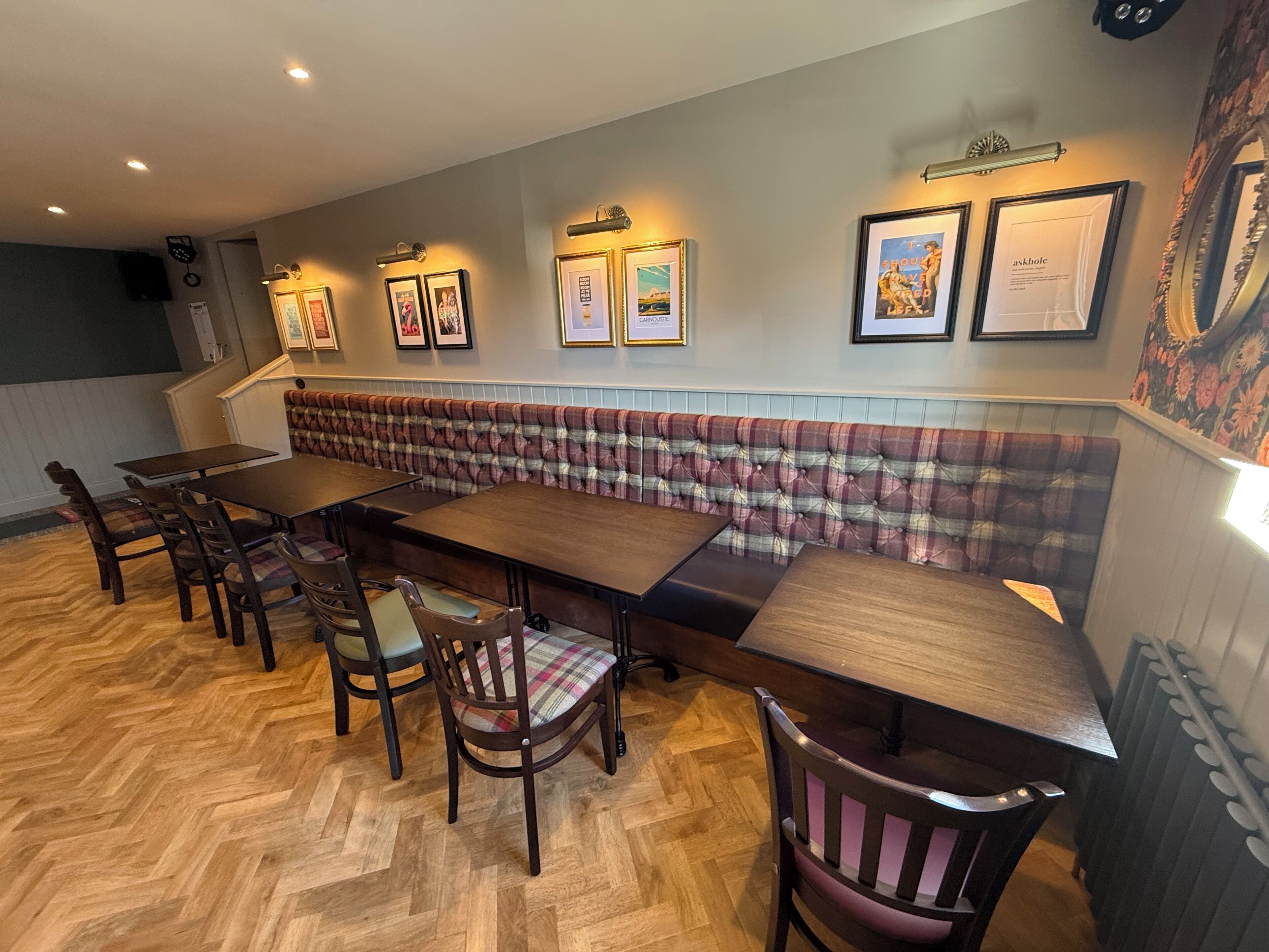 A dining area with a long wooden table, upholstered bench seating, and wooden chairs.