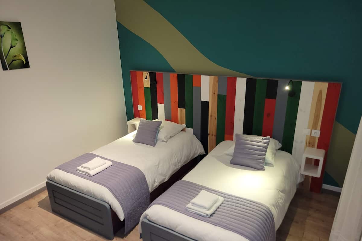 A room with two beds, each with a headboard featuring a colorful striped pattern.