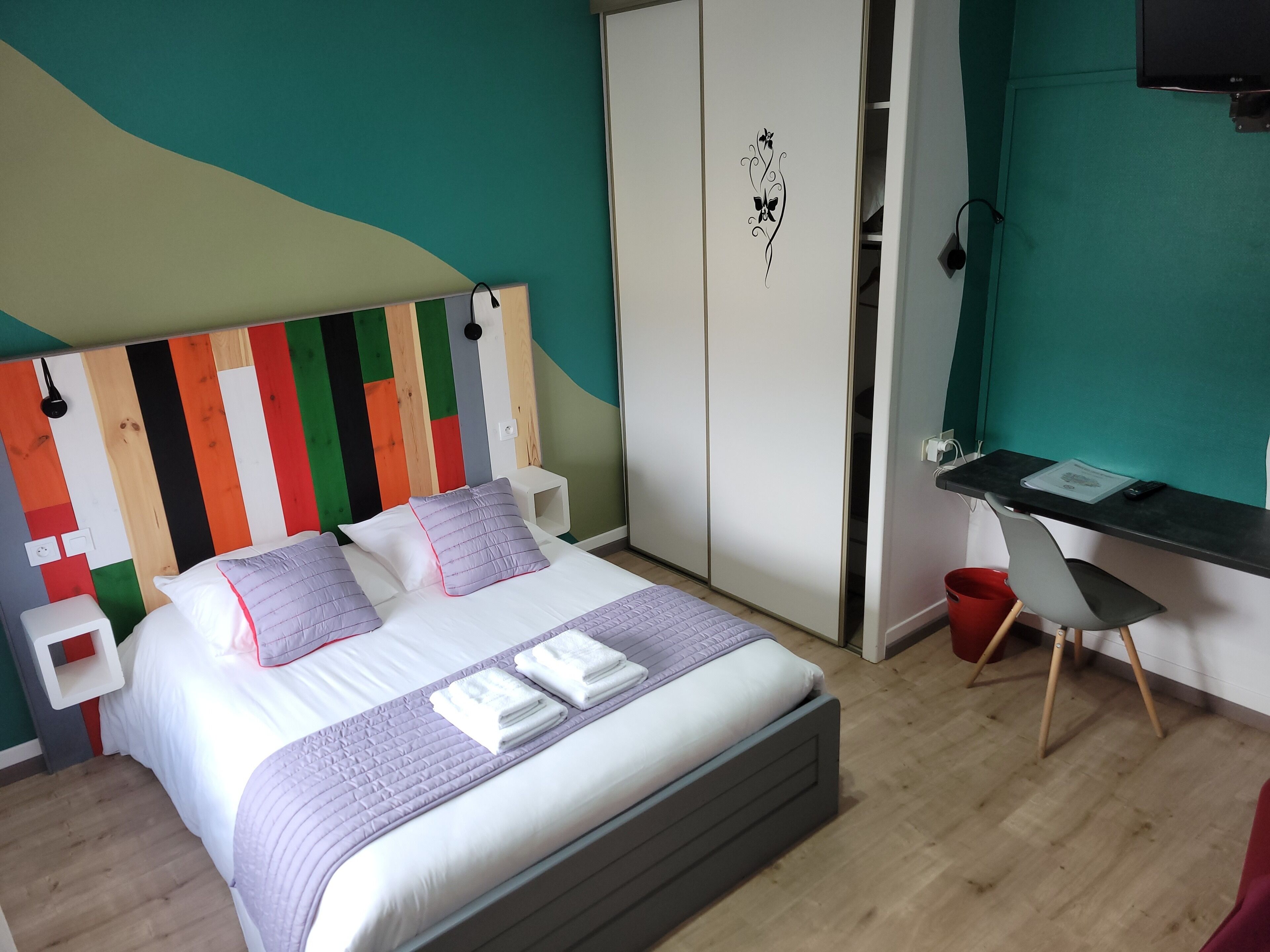 Ein Schlafzimmer mit Bett, Schreibtisch und Kleiderschrank.