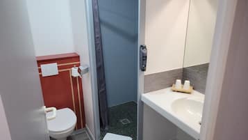 Un baño con inodoro, ducha y lavamanos.