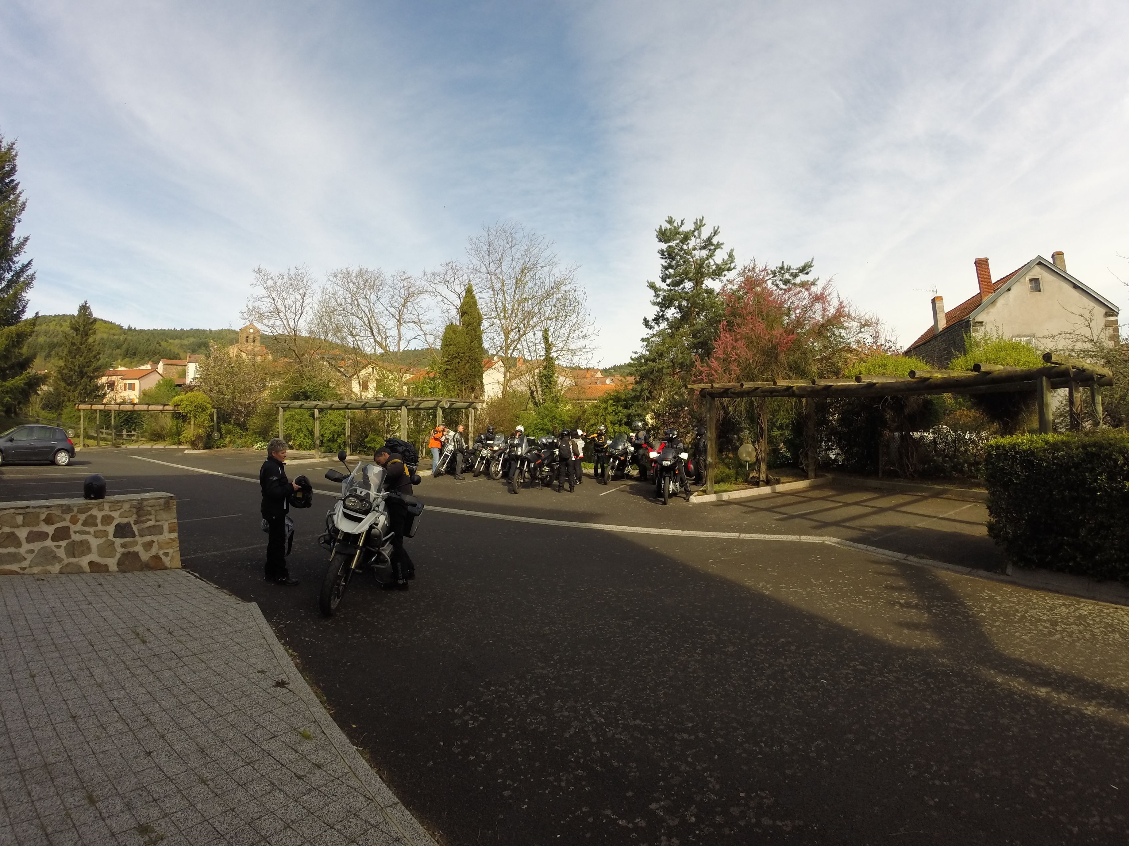 Una carretera pavimentada con un muro de piedra a la izquierda y una zona techada con motocicletas a la derecha.