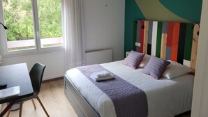 Un dormitorio con cama, escritorio y silla.