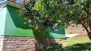 A building with a green exterior and a brick base. - Residencial Casa Verde (Gramado)