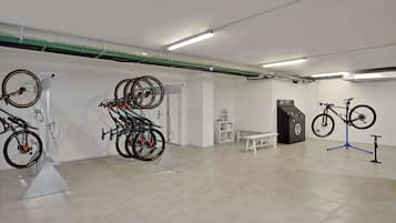 Amplio espacio interior con bicicletas montadas en soportes, un banco blanco y una exhibición de herramientas.