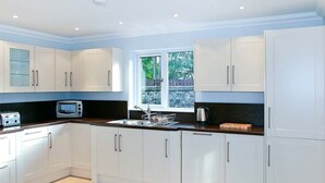 Una cocina moderna con armarios blancos, encimera negra y una ventana que proporciona luz natural.