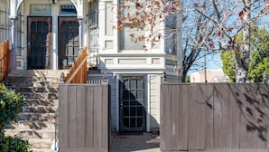 A gated entrance to a building with a stone staircase leading up to a door. - Bright & Spacious One Bedroom Apartment (Oakland)