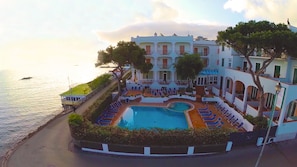 A hotel with a pool, a view of the sea, and a white building with balconies. - Grand Hotel Ischia Lido (Ischia)
