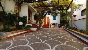 A covered walkway with patterned flooring leading to a building entrance. - Grand Hotel Ischia Lido (Ischia)
