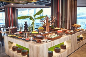 A buffet setup with various food items and a decorative tree centerpiece.