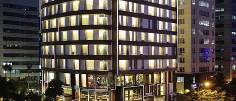 A multi-story hotel with illuminated windows and a modern architectural design.