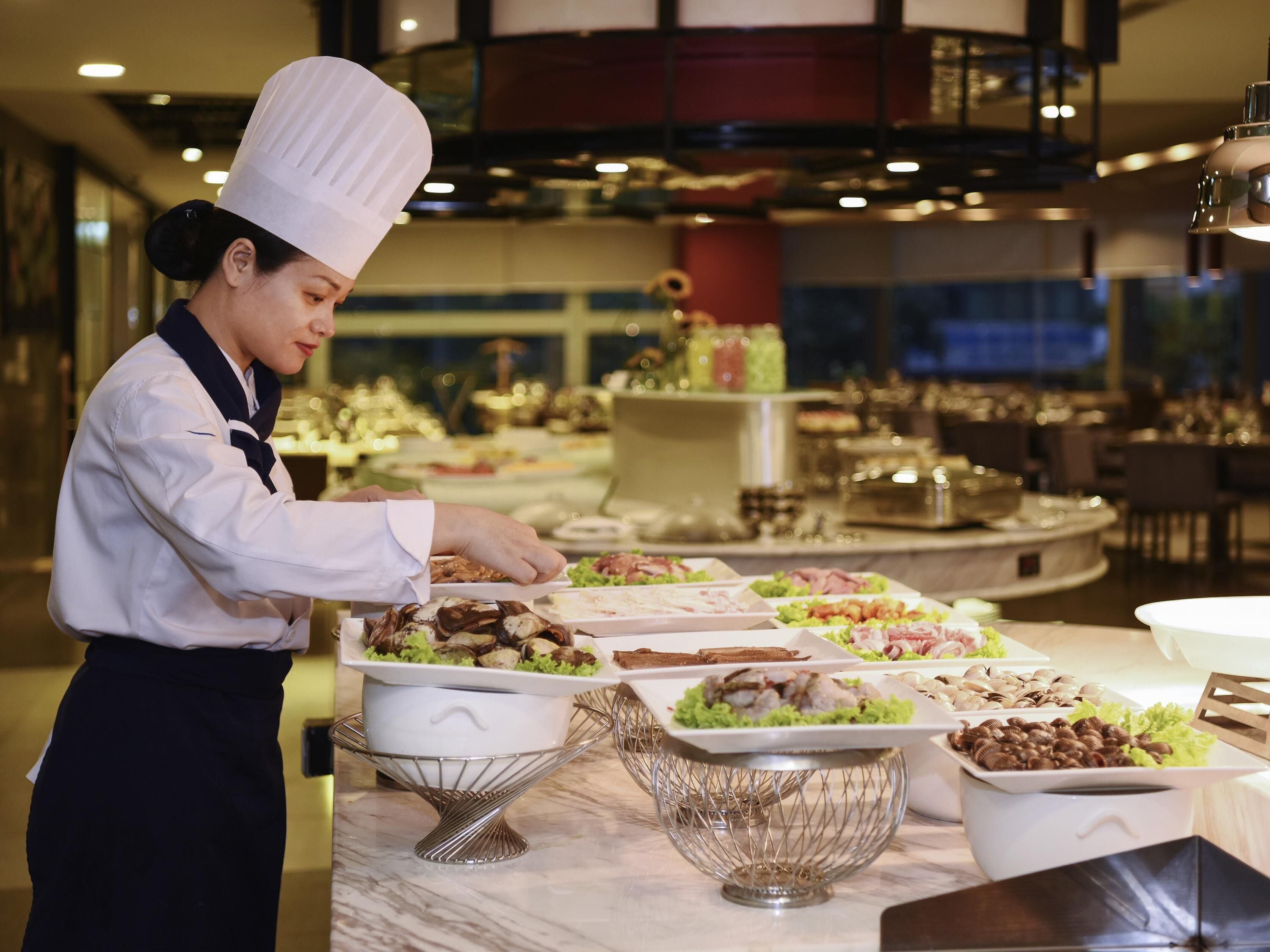 Un buffet proposant une variété de plats et un chef cuisinier en uniforme.
