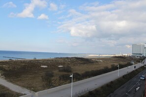 Une route côtière avec une plage et un hôtel en arrière-plan.
