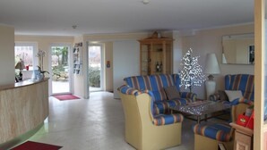 Una sala de estar con sofás a rayas, una mesa de centro y un árbol de Navidad.