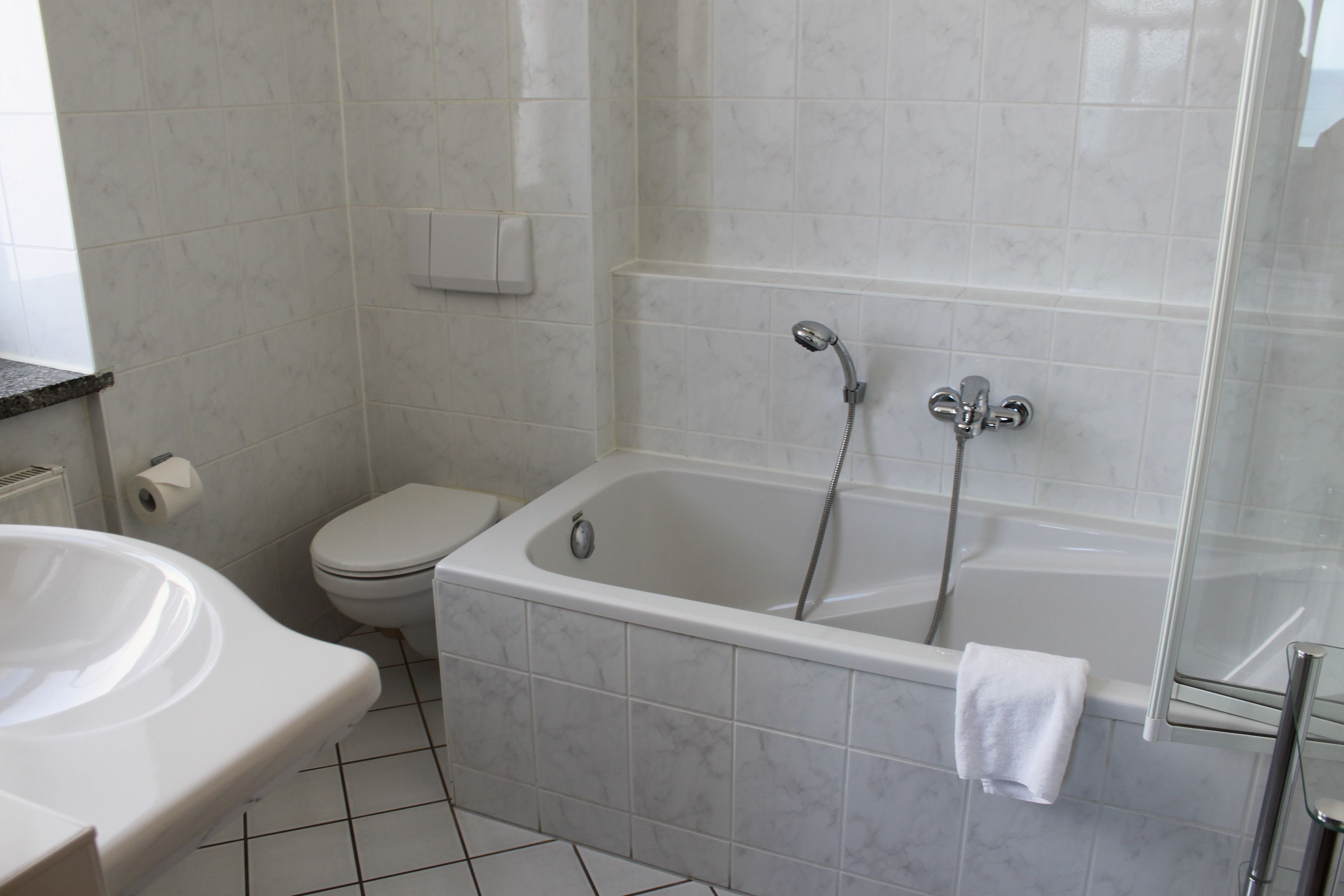 A bathroom with a bathtub, toilet, and sink.