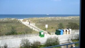 Una carretera costera con vistas al mar, un camino pavimentado y algunas construcciones verdes.
