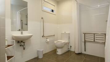 A modern bathroom with a white sink, toilet, and shower.