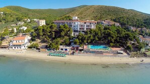 Un hôtel situé sur la côte, avec plusieurs étages, une piscine et un espace de plage.