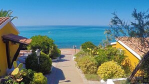 A pathway leading to a coastal view with a clear sky and calm sea. - Baia Paraelios  (Parghelia)