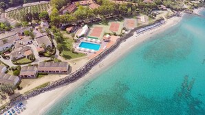 An aerial view of a coastal resort with a swimming pool, beach, and villas. - Sabbie Bianche (Parghelia)