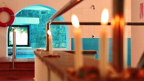 A bathroom with a stone wall, a blue-tiled shower area, and a red lifebuoy on the wall. - Villaggio dei Pini (Sorso)