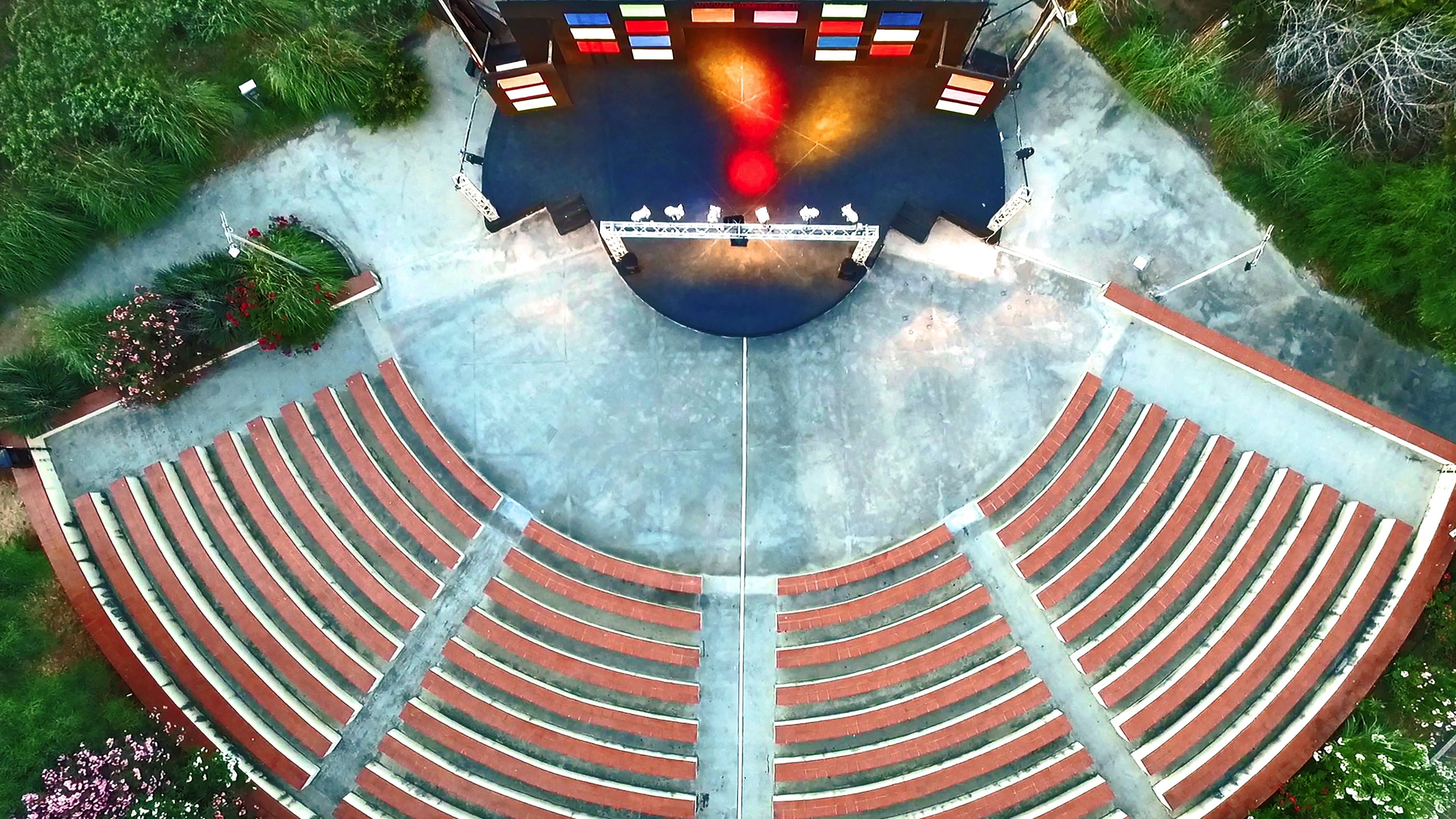 Un anfiteatro all'aperto con gradinate a più livelli e un palco centrale.