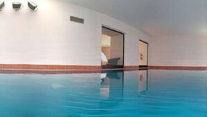 An indoor swimming pool with arched ceilings and large windows. - Villaggio dei Pini (Sorso)