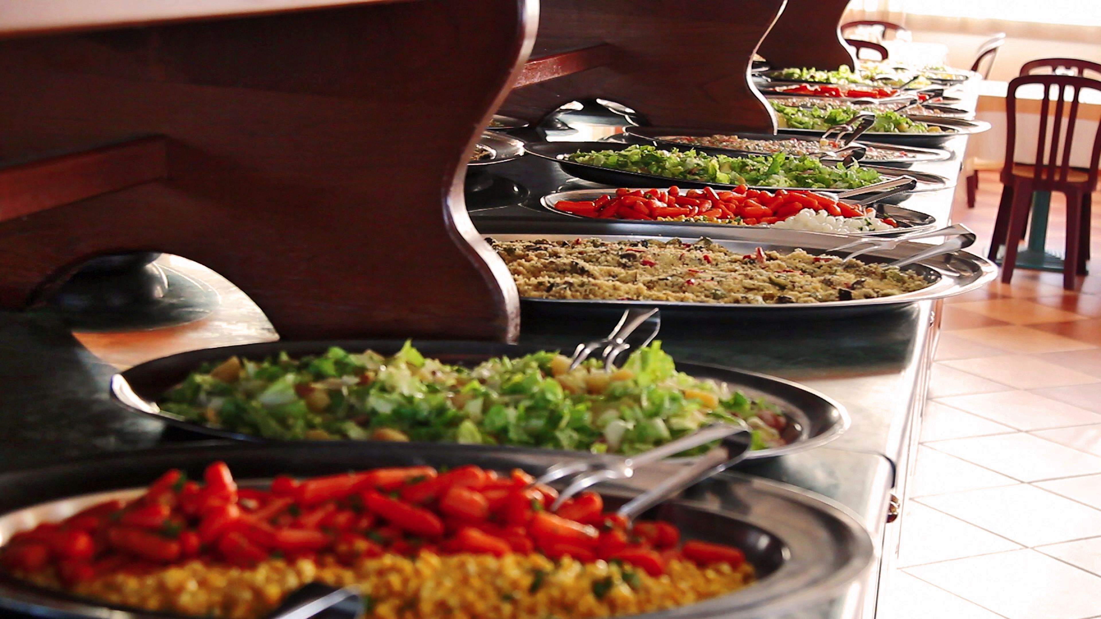 Un buffet con diversi piatti, tra cui insalate, riso e verdure.