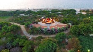 An amphitheater surrounded by lush greenery and a beach in the background. - Villaggio dei Pini (Sorso)