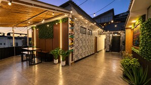 An outdoor patio area with a wooden pergola, string lights, and potted plants. - Ica Adventures II - Hostel (Ica)
