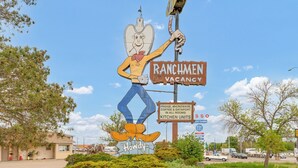 A ranch-themed sign with a cartoon character holding a lasso, indicating a no vacancy status. - Ranchmen Motel (Medicine Hat)
