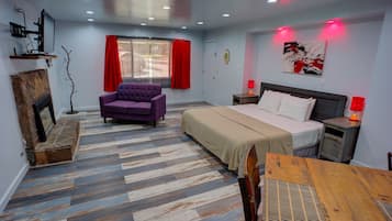A hotel room with a bed, a sofa, a table, and a chair.