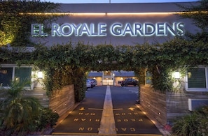 The entrance to El Royale Gardens with a sign above the entrance and a parking area with directional arrows. - El Royale Gardens Near Universal Studios (Studio City)
