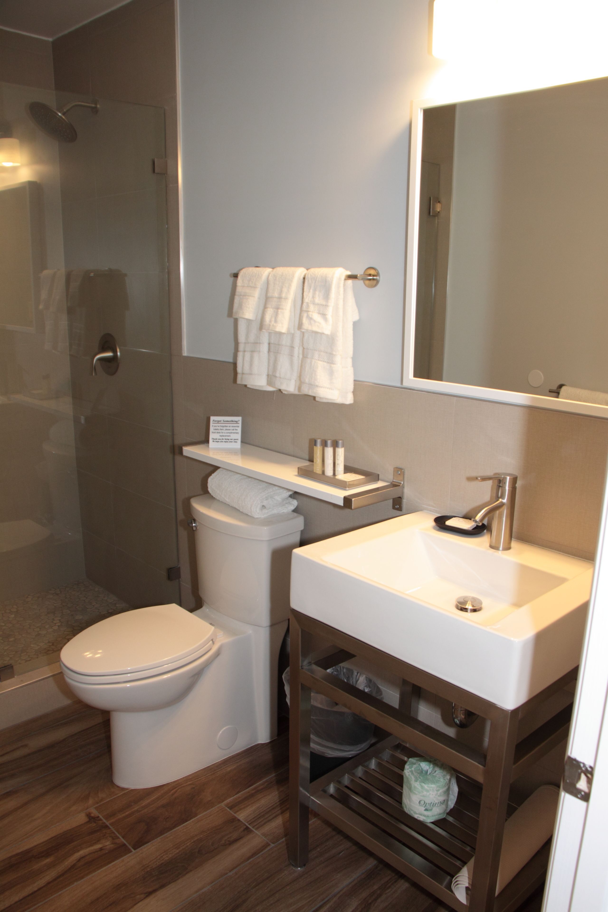 Une salle de bain équipée d’une douche, de toilettes, d’un lavabo et d’un miroir.