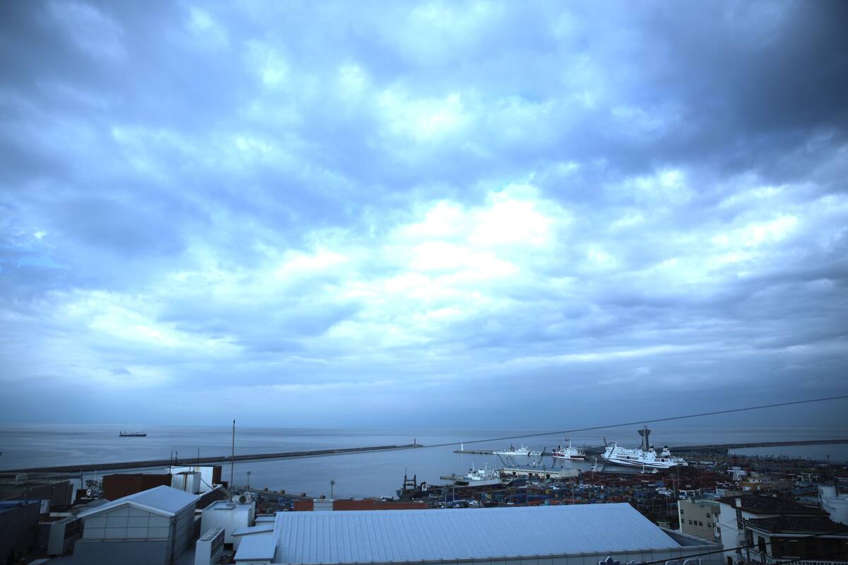 A coastal town with a view of the sea and a large ship docked at the port.