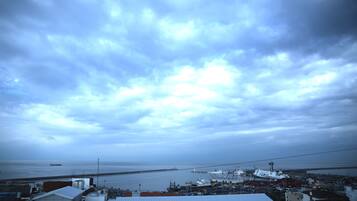 A coastal town with a view of the sea and a large ship docked at the port.