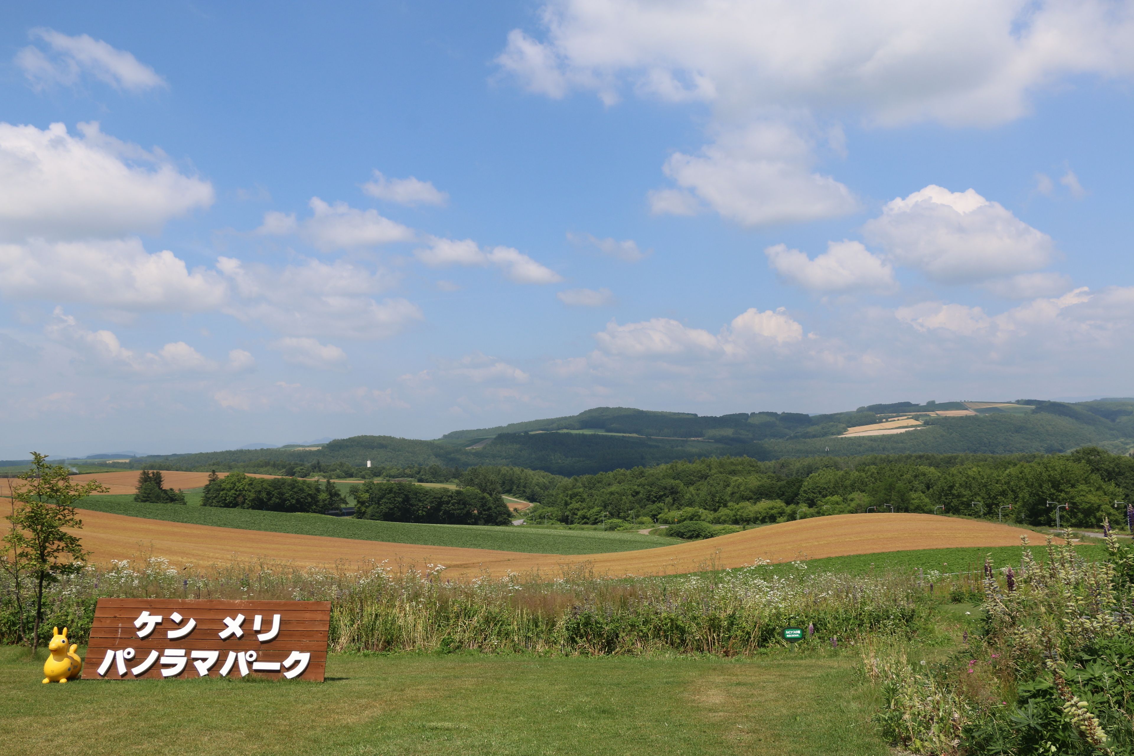 A sign in a field with a view of rolling hills and a clear sky.