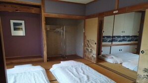 A traditional Japanese room with tatami flooring, a shoji screen, a wooden wardrobe, and a small washstand. - Cottage Ken&Mary (Biei)