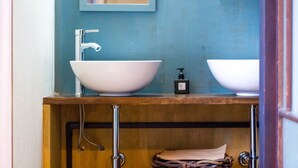 A bathroom with a large white sink, a mirror, and a wooden vanity. - Guesthouse MADO – Hostel (Nagoya)