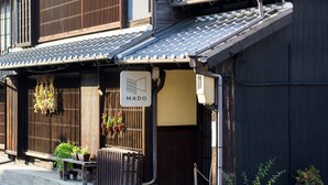 A traditional Japanese building with a tiled roof, wooden sliding doors, and a sign reading "MADO". - Guesthouse MADO – Hostel (Nagoya)