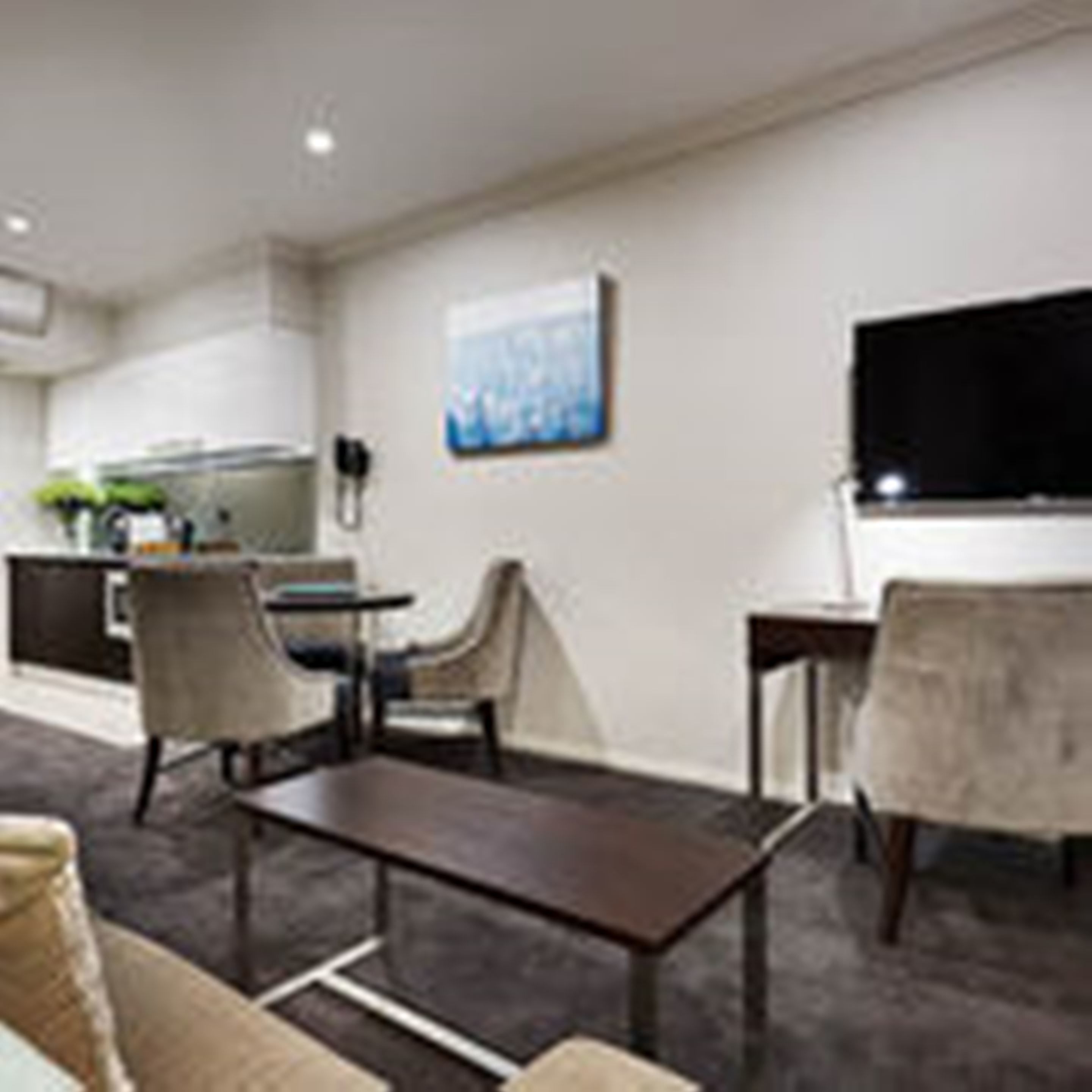 Ein modernes Wohnzimmer mit einer Couch, einem Couchtisch und einem Fernseher.